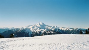 藍天下白雪覆蓋的山脈，前景積雪。