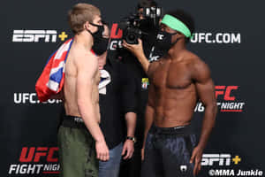 兩名戴著口罩的MMA拳手在UFC稱重活動中面對面站立。
