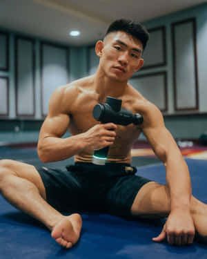 運動員在訓練墊上使用按摩槍