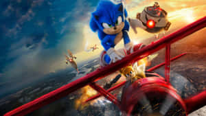 Sonic the Hedgehog 和 Tails 駕駛一架紅色雙翼飛機，Dr. Eggman 在夕陽天空下追趕他們。 — 超音鼠 壁紙
