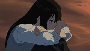 一個悲傷的動漫女孩在溫暖的橙色夕陽天空下擁抱自己。