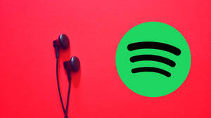 黑色耳機在紅色背景上與Spotify標誌相鄰