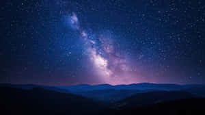 銀河系在星夜下於黑暗山脈剪影上方發光