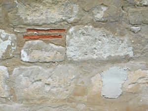 風化石牆，嵌有紅磚條，灰泥剝落