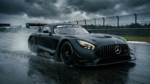 黑色平治AMG GT3賽車在暴雨天空下的濕滑賽道上飛馳