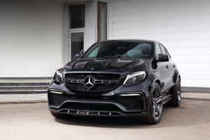 黑色Mercedes-AMG GLE63 S Coupe停在一棟現代建築前。 — Surface Laptop 壁紙
