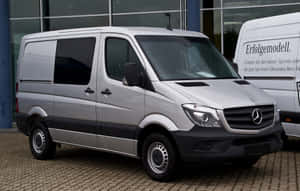 銀色 Mercedes-Benz Sprinter 客貨車停泊在經銷商外。 — Steam Deck OLED 壁紙