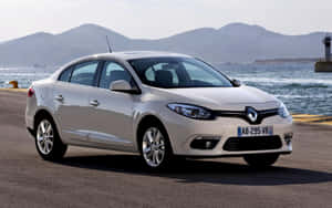 銀色雷諾轎車停泊在海邊，背後有山脈。 — Steam Deck 壁紙