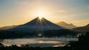 山間湖上的日出，伴隨著薄霧和金色光芒