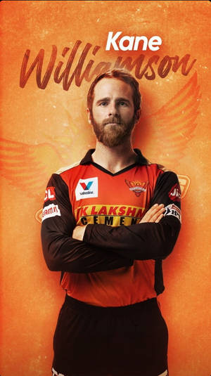 板球運動員 Kane Williamson 身穿球隊球衣，在橙色背景上雙臂交叉。