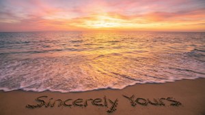 夕陽下的海洋，海浪沖刷著寫有「Sincerely Yours」的沙灘。