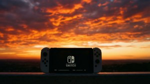 Nintendo Switch 主機剪影在鮮豔的橙色和紫色日落天空前。