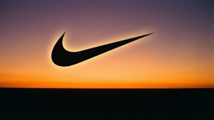 黑色Nike剔形標誌襯托橙色和紫色日落天空