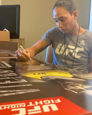 女性UFC拳手在宣傳海報上簽名。