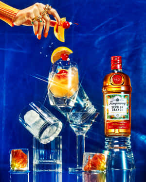 手將櫻桃和橙片放在雞尾酒杯上，旁邊是 Tanqueray Sevilla Orange 瓶子。
