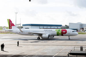 Air Portugal飛機喺濕滑停機坪上，附近有人，天空多雲
