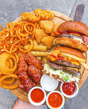 戶外美食拼盤：漢堡、薯條、雞翼和醬料。 — 美食 壁紙