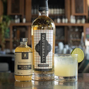 Tattersall Aquavit酒瓶和吧檯上的青檸雞尾酒