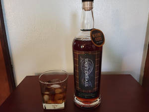室內木桌上的一瓶威士忌和加冰的酒杯。