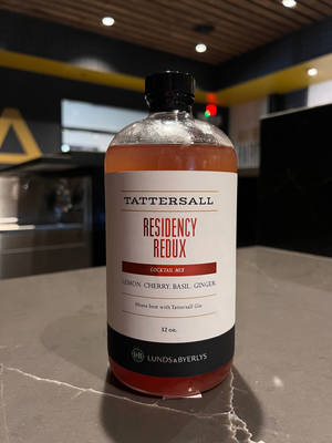 一瓶 Tattersall Residency Redux 雞尾酒調配液放在大理石酒吧檯面上。