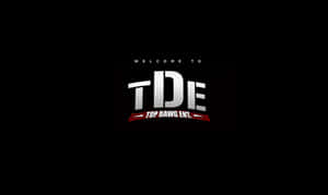 Top Dawg Entertainment 標誌，帶有銀色 TDE 字母和紅色橫幅，位於黑色背景上。