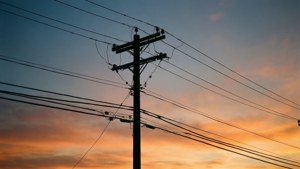 電線桿和電線在色彩繽紛的日落天空下的剪影。