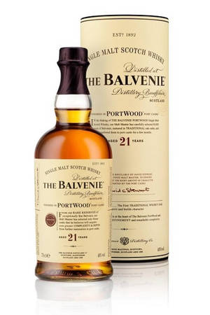 一瓶Balvenie 21年威士忌及其盒子置於反光表面上。