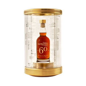 一瓶60年Balvenie威士忌，放在金色和玻璃展示盒中，並刻有語錄。