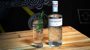 Botanist 氈酒瓶和迷迭香雞尾酒在木桌上。