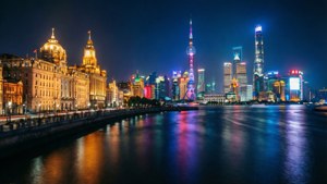 上海夜景天際線，燈火通明的建築倒映在黃浦江上。