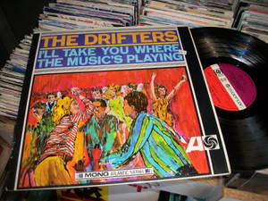 The Drifters 跳舞插圖的黑膠唱片封套，周圍環繞著一堆堆唱片。 — 音樂 GIF 壁紙