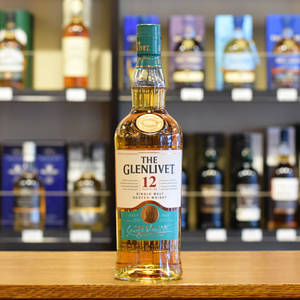在酒類商店的木製櫃檯上放著一瓶 Glenlivet 12 年蘇格蘭威士忌。