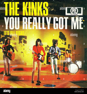The Kinks 樂隊在明亮的舞台燈光下，現場演奏結他和鼓。 — 復古 壁紙