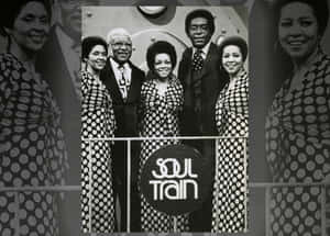 Soul Train 演員穿著圓點連衣裙和西裝在舞台上微笑。