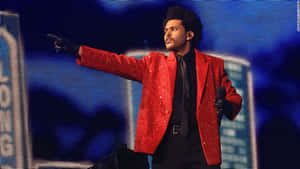 The Weeknd 著住紅色閃亮外套喺燈光舞台唱歌。 — 紅色美學 壁紙