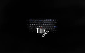 黑色手提電腦鍵盤，帶有發光白色Think Linux標誌及紅點。