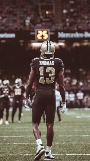 美式足球員Thomas（13號）在比賽中站在球場上。
