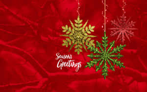 三個懸掛的閃閃發光雪花裝飾品，置於紅色雪白樹枝上，附有 Seasons Greetings 文字。