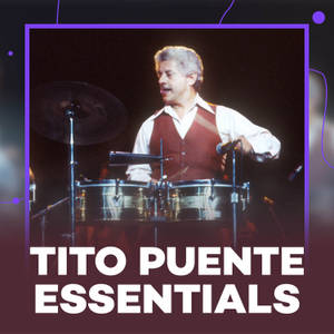Tito Puente 在舞台上現場表演，使用鼓和麥克風。