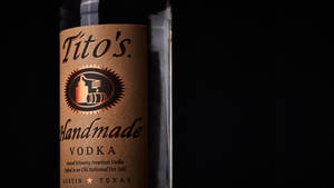深色背景下的 Tito's Handmade Vodka 酒瓶標籤