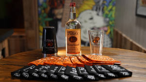 Tito's伏特加酒瓶和玻璃杯放在木製吧枱上，配有品牌餐巾。