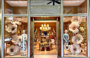 Tory Burch 店舖正面，有人體模型和花卉展示。