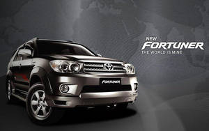 黑色豐田 Fortuner SUV 在攝影棚燈光下，帶有「The World Is Mine」標語。