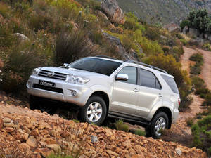 銀色豐田 Fortuner SUV 在岩石山路上行駛。