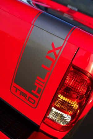 紅色豐田 Hilux TRD 貨車車尾，帶有黑色條紋和發光尾燈。
