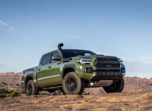 橄欖綠色的豐田Tacoma TRD Pro皮卡車在藍天下的岩石沙漠地形上。