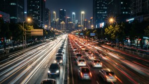 夜間城市高速公路，帶有汽車燈光流動和高聳的發光建築