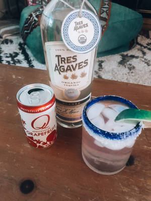 一瓶龍舌蘭酒、一罐西柚梳打水和一杯鹽味瑪格麗特在木桌上。 — 3:4 壁紙