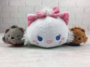 三個Tsum Tsum毛絨玩具，包括一隻戴粉紅色蝴蝶結的白貓。 — 公主與青蛙 壁紙