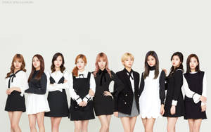 九位K-pop偶像穿著黑白服裝為攝影棚照片擺姿勢。